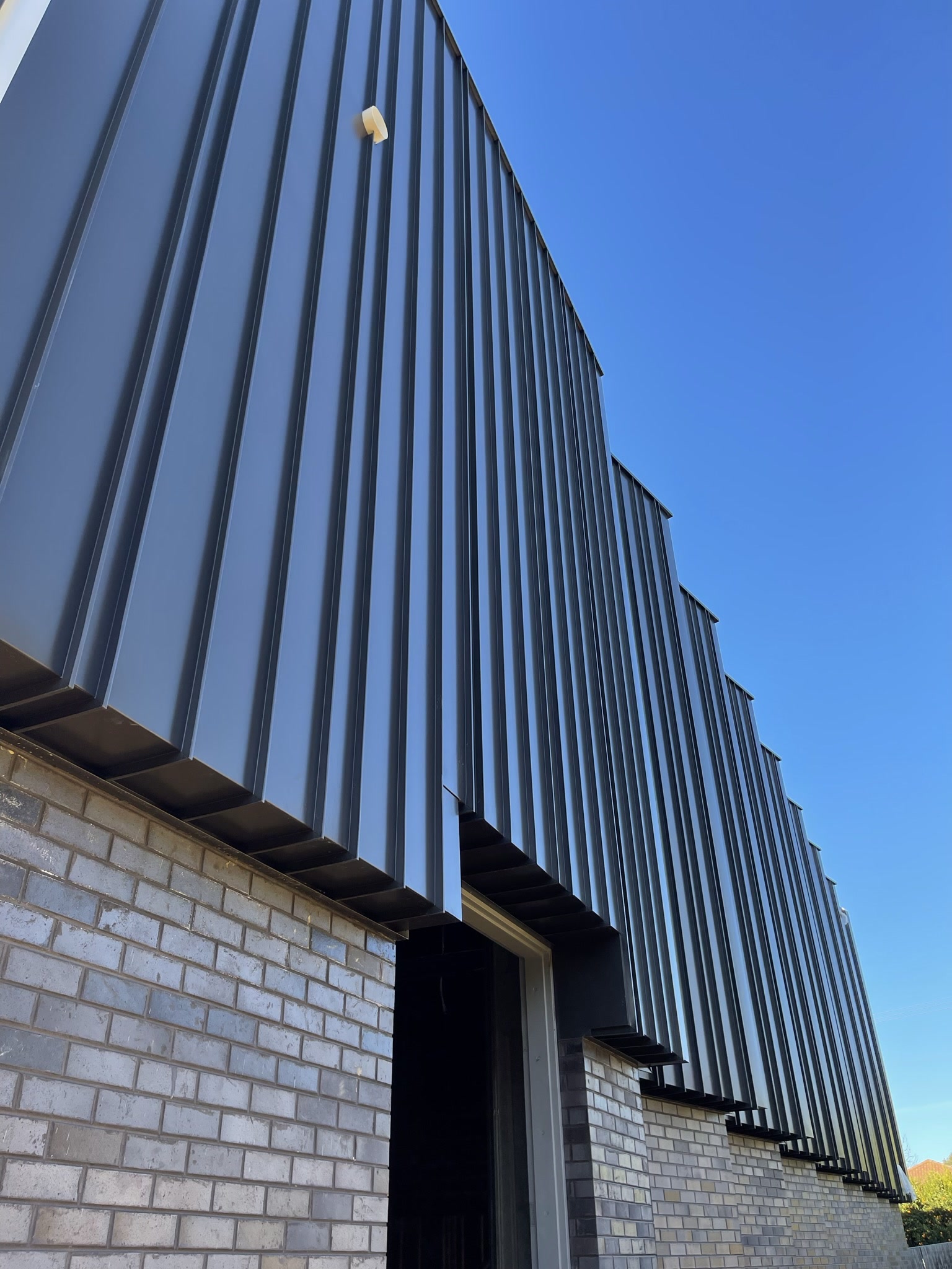 Emmaus College facade with dark standing-seam cladding
